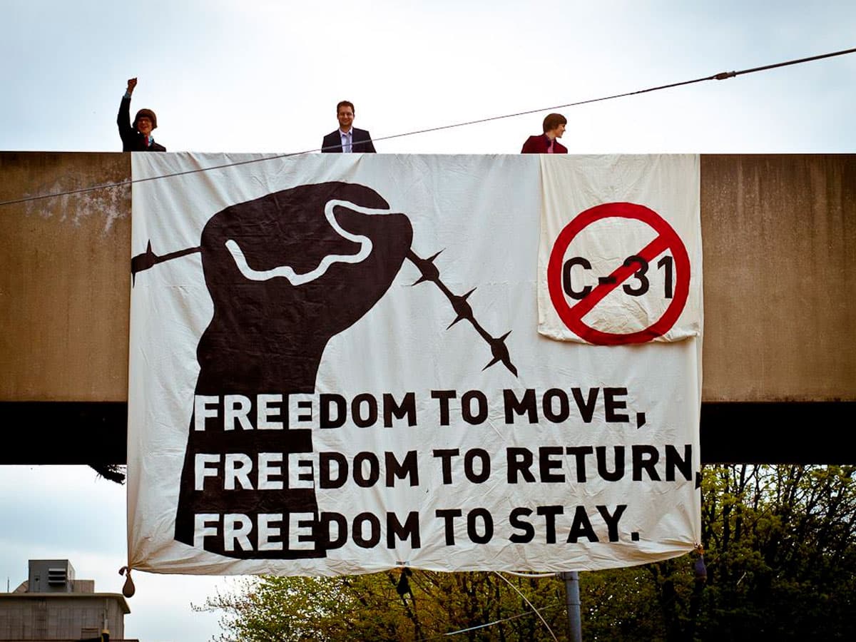 Flag on a bridge that says 'Freedom to move, freedom to return, freedom to stay'