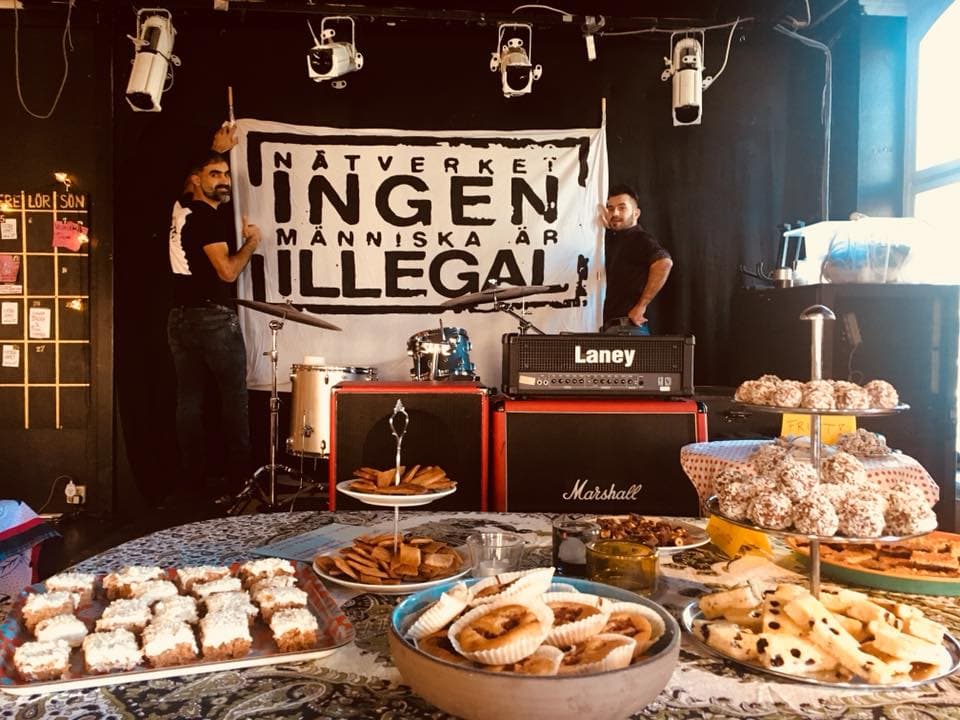 Fika and a sign that says 'Ingen människa är illegal'
